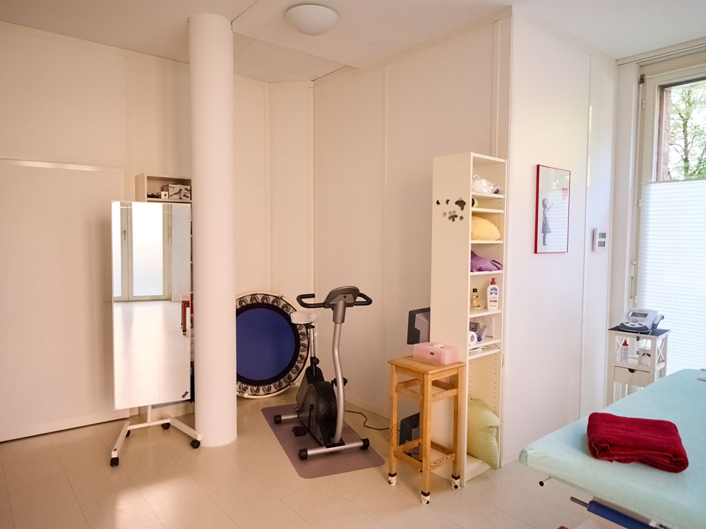 Behandlungsraum mit Trainingsgeräten und Ergometer